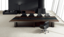 plush boardroom with dark wood and leather finish table and leather chairs