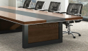 wooden meeting table with black leather chairs
