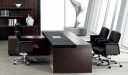 plush office cabin with dark wood office table and black leather chairs