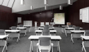 classroom with white tables and gray chairs