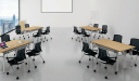 classroom table with light oak laminate top and black chairs