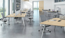 modern office with workstations in light wood finish and chairs