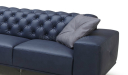 blue leather sofa with tufted back and gray cushion