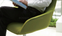 a person sitting in an easy chair upholstered in green fabric