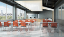 classroom with tables and orange color plastic chairs